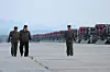 North Korean leader Kim Jong-un, center, oversees the country's ″power demonstration firing″ of 600 mm super-large multiple rocket launchers the previous day, in a photo carried by its official Korean Central News Agency on Friday. [YONHAP]