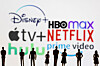 Toy figures of people are seen in front of Disney+, HBO Max, Apple TV, Netflix, Hulu and Prime Video logos. [REUTERS/YONHAP]