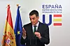 Pedro Sanchez speaks beside Spanish and EU flags at a Brussels press conference.