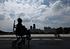 Silhouetted wheelchair user at the National Museum of Korea with Seoul skyline and pedestrians in the background.