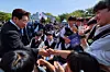 President Lee Jae Myung, left, shakes hands with students after a ceremony to mark the 66th anniversary of the 1960 pro-democracy uprising at the April 19th National Cemetery in Seoul on April 19. [BLUE HOUSE]