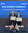 Lee Sang-bong, executive vice president and head of naval ship design division at HD Hyundai Heavy Industries, left, and Andrew Nuss, head of maritime at Anduril, pose for a photo after signing memorandum of understanding in the development of unmanned underwater vehicles at the Sea, Air and Space Exposition 2026 in Washington D.C. on April 22. [HD HYUNDAI]