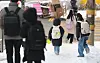 Children walk on snow-covered streets near an elementary school in western Seoul in February. [YONHAP]