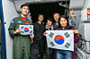 A Korean family poses with an Air Force officer aboard a military plane bringing them and more than 200 others home from Saudi Arabia on March 15. [YONHAP]