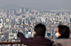 People look out at apartments from a hill in Seoul on March 10. [NEWS1]