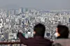 People look out at apartments from a hill in Seoul on March 10. [NEWS1]