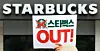 A member of a civic organization holds up a card reading ″Starbucks OUT″ in front of a Starbucks cafe in Gwanghwamun, central Seoul, on May 27. [NEWS1]