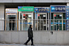 A pedestrian passes by automated teller machines of major banks installed in Seoul on Dec. 21, 2025. [YONHAP]