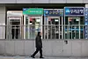 A pedestrian passes by automated teller machines of major banks installed in Seoul on Dec. 21, 2025. [YONHAP]