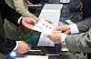 A wedding guest hands over a congratulatory cash gift at a wedding reception desk. [JOONGANG ILBO]