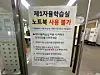 A poster inside Jeongdok Library in Jongno District, central Seoul, informs visitors that laptops cannot be used in the reading room behind the glass door. [HAN CHAN-WOO]