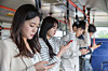 People on a bus look at smartphones and do not engage in an undated photo. [GETTY IMAGES PRO]