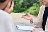 A person writes a memo while talking with another person in this file photo. [GETTY IMAGES PRO]