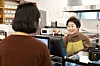 An older adult working at a cafe takes an order from a customer in an undated photo. [GETTY IMAGES PRO]
