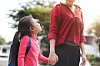 A woman holds hands with a child [SHUTTER STOCK]