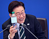 President Lee Jae Myung holds a plastic bottle that can be fully recycled during a Cabinet meeting held at the Blue House on April 28. [JOINT PRESS CORPS]