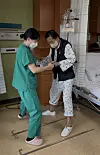 A physical therapist, left, at Seoul Asan Medical Center assists a patient with walking therapy. The hospital provides early rehabilitation treatment during hospitalization. [SEOUL ASAN MEDICAL CENTER]