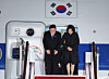 President Lee Jae Myung, left, and first lady Kim Hea Kyung offer greetings upon their arrival at Seoul Air Base in Seongnam, Gyeonggi, on March 4, after returning from their trip to Singapore and the Philippines. [YONHAP]