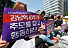 Participants hold signs during a memorial rally marking the 10th anniversary of the Gangnam Station murder case, organized by women’s civic groups near Exit 10 of Gangnam Station in southern Seoul on May 17. The signs say, ″Take action beyond remembering the 10th anniversary of Gangnam Station.″ [YONHAP]