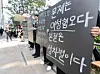 Participants hold signs during a memorial rally marking the 10th anniversary of the Gangnam Station murder case, organized by women’s civic groups near Exit 10 of Gangnam Station in southern Seoul on May 17. [YONHAP]
