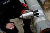 Ukrainian military serviceman Igor Ovcharruck holds a defused cluster bomb from an MSLR missile, among a display of pieces of rockets used by Russian army, that a Ukrainian munitions expert said did not explode on impact, in the region of Kharkiv, Ukraine, October 21, 2022. [REUTERS/YONHAP]