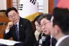 President Lee Jae Myung, left, listens as Financial Services Commission Chairman Lee Eog-won speaks at a public-private roundtable to review measures to reform and stabilize capital markets at the Blue House in central Seoul on March 18. [JOINT PRESS CORPS]
