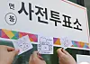 People take photos of slips of paper with voting stamps to prove they voted for the local elections on May 29, the first day of the early voting period. [YONHAP]