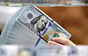 An employee holds up dollar bills at Hana Bank's Counterfeit Notes Response Center in Jung District, central Seoul, on Jan. 6. [NEWS1]