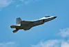 A KF-21 Boramae fighter jet flying against a blue sky near Seoul Air Base.
