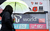 A pedestrian walks by mobile phone stores in Seoul on Dec. 23, 2024. [NEWS1]
