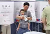 A voter casts a ballot while carrying a baby in a baby carrier at a polling station set up at the Gangnam District Office in Gangnam District, Seoul, on June 3, the day of the 9th nationwide local elections. [NEWS1]