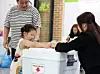 A child who came with her mother places a ballot into the box at a polling station in Daegu on the morning of June 3, the day of the 9th nationwide local elections. [NEWS1]