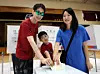 Voters cast their ballots with their child at a polling station set up at Eonju Middle School in Gangnam District, Seoul, on June 3, the day of the 9th nationwide local elections and National Assembly by-elections. [NEWS1]