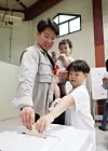 A family votes at a polling station set up in the indoor ssireum (Korean wrestling) arena of the Seongnam Sports Complex in Jungwon District, Seongnam, Gyeonggi, on June 3, the main voting day for the 9th nationwide local elections and National Assembly by-elections. [NEWS1]