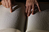 A Braille reader traces Braille with their hands. [YONHAP]