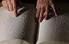 A Braille reader traces Braille with their hands. [YONHAP]