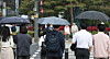 People holding umbrellas stand at a crosswalk in central Seoul on April 20. [NEWS1]