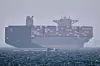 A container ship sits at anchor as a small motorboat passes in the foreground in the Strait of Hormuz off Bandar Abbas, Iran, Saturday, May 2. (Amirhosein Khorgooi/ISNA via AP)