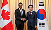 Korean Industry Minister Kim Jung-kwan, right, and Canadian Trade Minister Maninder Sidhu shake hands during their meeting in Seoul on March 31. [MINISTRY OF TRADE, INDUSTRY AND RESOURCES]