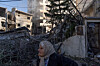 A woman stands next to a building destroyed by an Israeli strike, amid escalating hostilities between Israel and Hezbollah, as the U.S.-Israeli conflict with Iran continues, in Tyre, Lebanon, on March 24. [REUTERS/YONHAP]