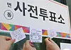 People take photos of slips with voting stamps to prove they voted for the local elections on May 29, the first day of the early voting period. [YONHAP]