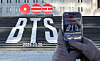 A tourist takes a photo of a promotional display for BTS's new album, ″Arirang,″ at the Sejong Center for the Performing Arts in Gwanghwamun Square in Jongno District, central Seoul on Jan. 22. [NEWS1]