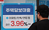 A man looks at a mortgage loan advertisement displayed outside a financial institution in Seoul on March 29. [YONHAP]