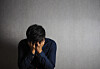 A distressed man buries his face in his hands. [GETTY IMAGES]