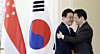 Korean President Lee Jae Myung, left, hugs Singaporean Prime Minister Lawrence Wong after their joint press briefing at the Foreign Ministry in Singapore on March 2. [JOINT PRESS CORPS]