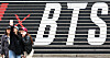 Tourists take a photo in front of a promotional display for BTS’s comeback live performance set up on the steps of the Sejong Center for the Performing Arts in Jongno District, central Seoul, on March 15. [NEWS1]