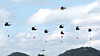 Military choppers showcase firefighting operations midair during training to extinguish wildfires in Gongju, South Chungcheong, on Oct. 22, 2025. [YONHAP]