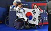 Lee Yong-seok, second to left, and Baek Hye-jin, right, who won silver in wheelchair curling mixed doubles at the 2026 Milan-Cortina Winter Paralympics, pose with coach Park Kil-woo at the Cortina Curling Olympic Stadium in Cortina, Italy, on March 11. [JOINT PRESS CORPS]