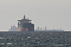 Cargo ships in the Gulf, near the Strait of Hormuz, as seen on March 11 from northern Ras al-Khaimah, amid the U.S.-Israeli war with Iran. [REUTERS/YONHAP]