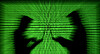 Silhouettes of laptop users are seen next to a screen projection of binary code in this illustration created on March 28, 2018. [REUTERS]